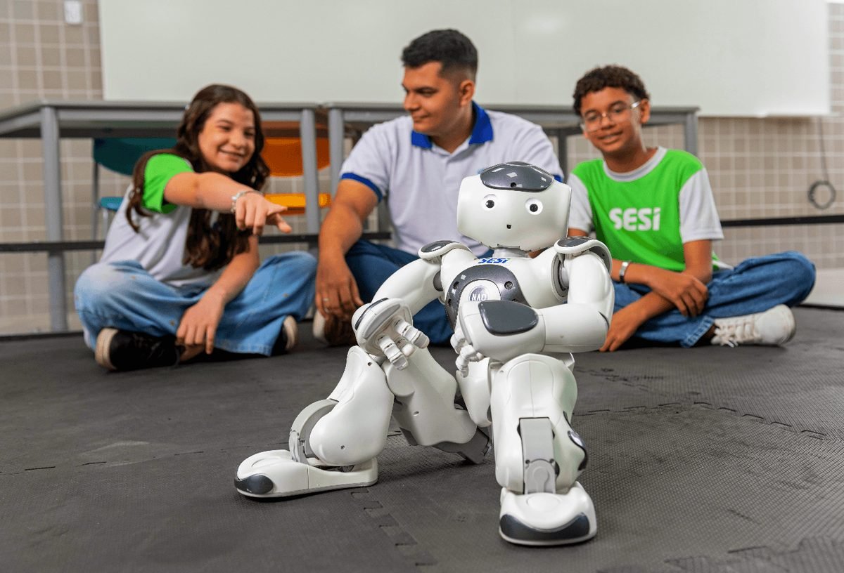 Estudantes com robô em atividade de robótica