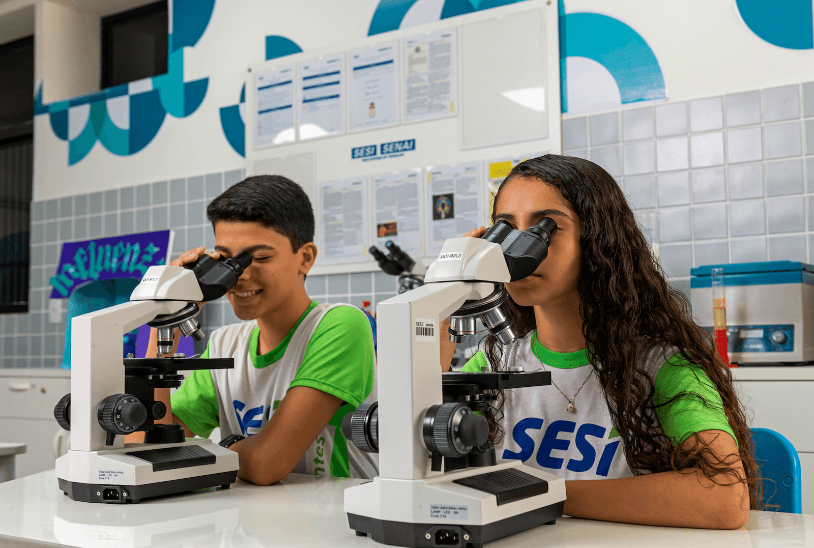 Estudantes no laboratório de ciências usando microscópios
